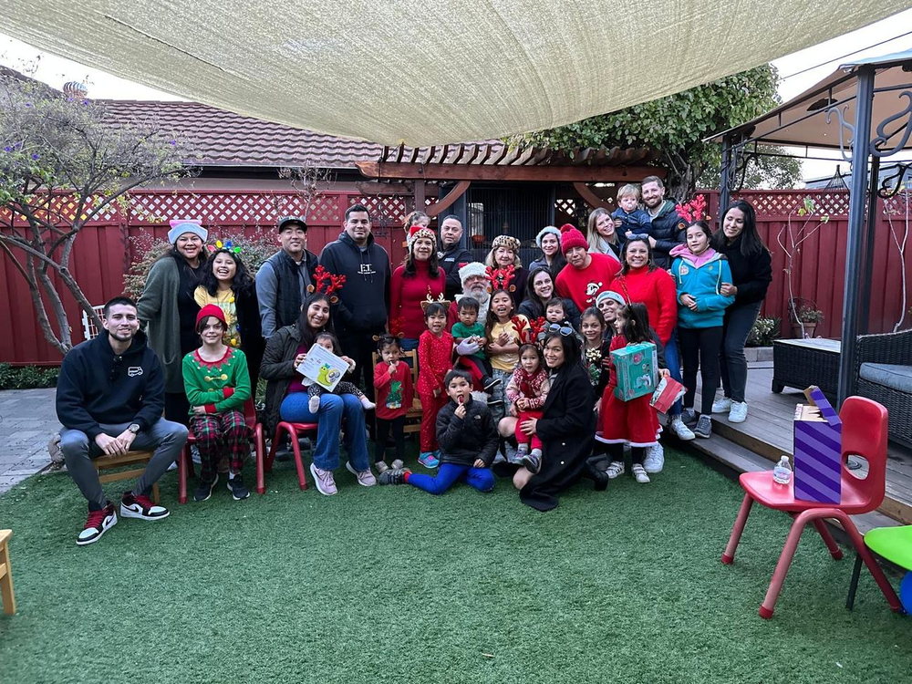 Group photo of the children and caregivers in our outdoor play area