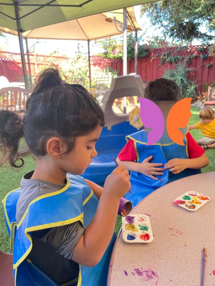 Two children concentrating on their paintings
