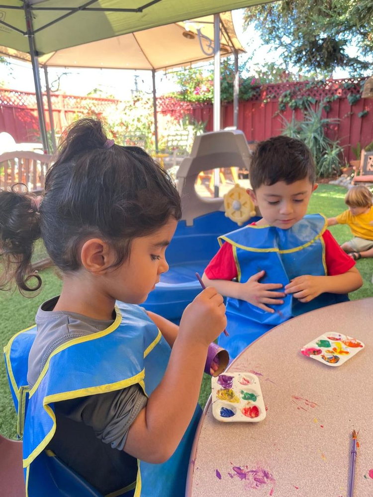 Two children concentrating on their paintings
