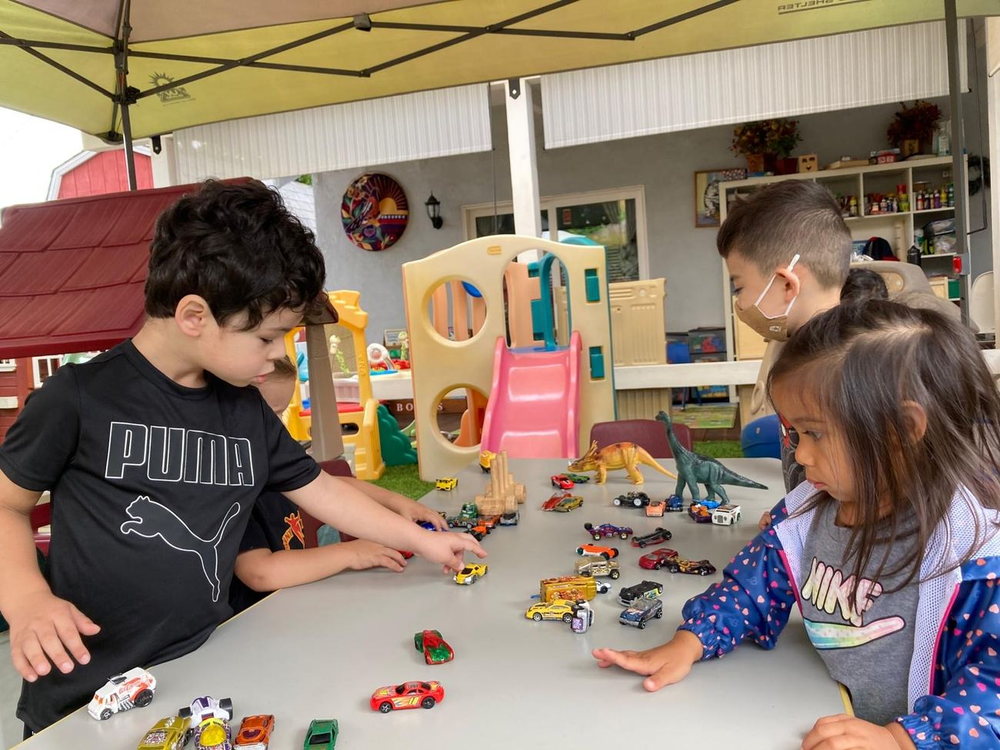 Niños jugando con bloques y la cocinita de juguete