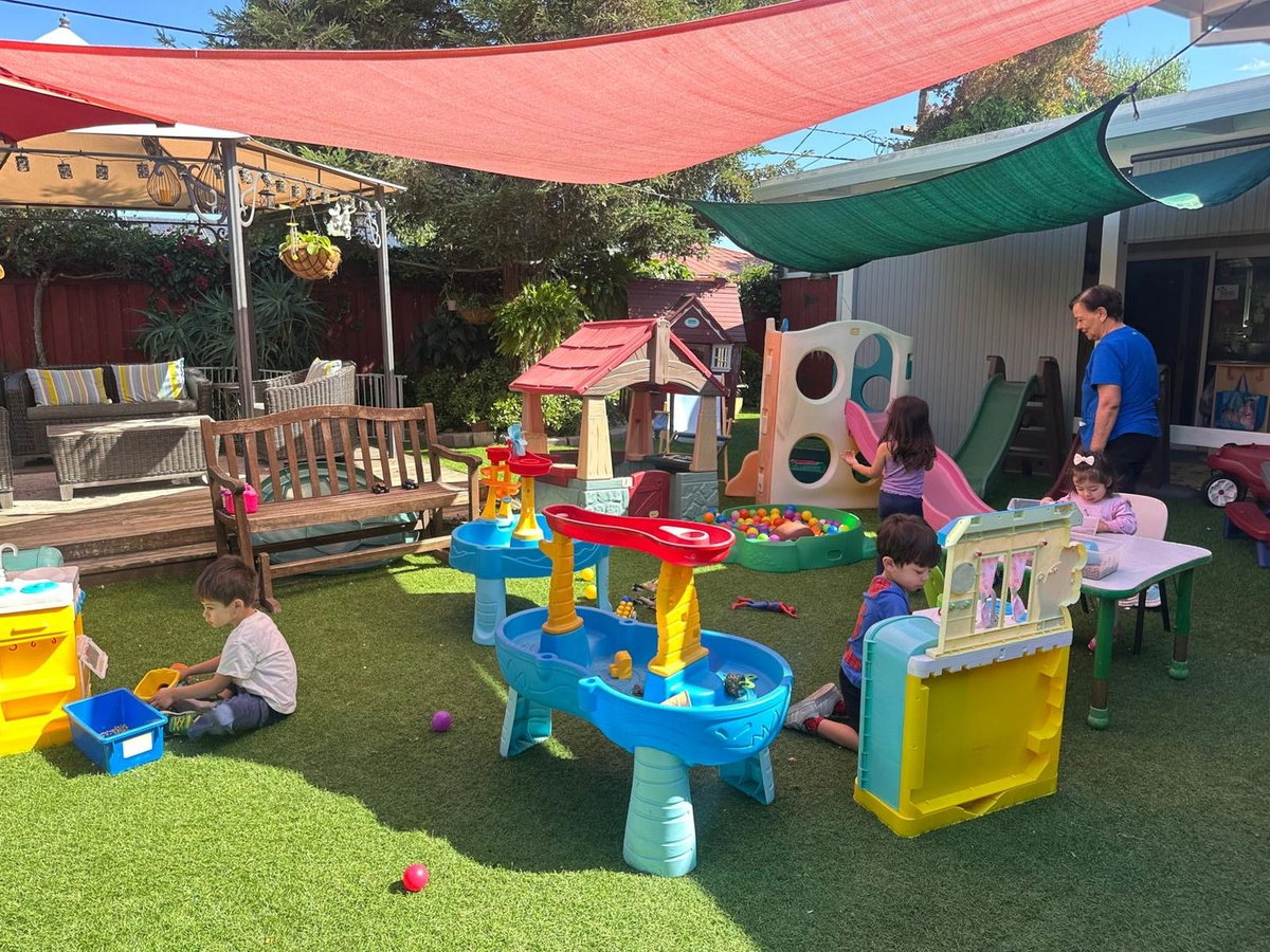 Children and caregiver playing together in our outdoor area