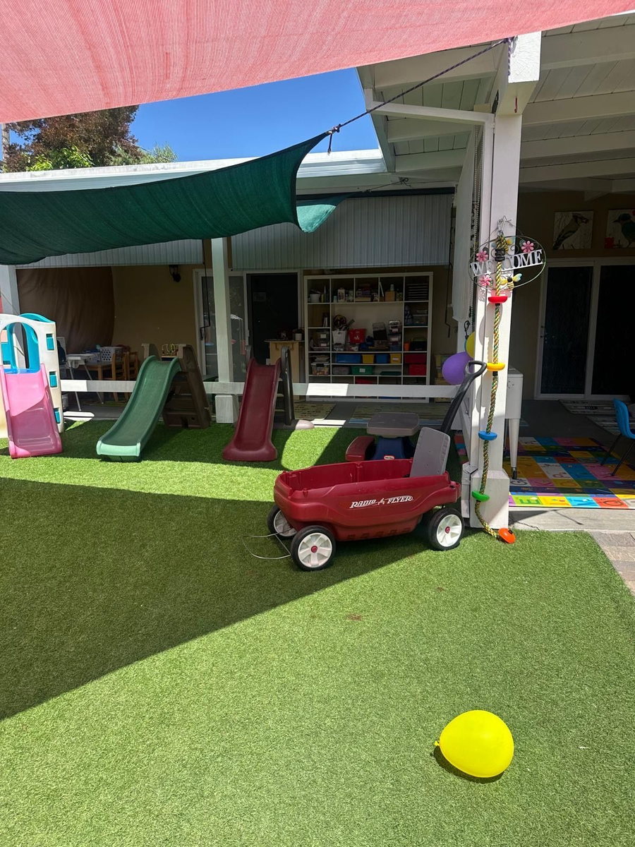 Outdoor slides and welcome sign at our home daycare